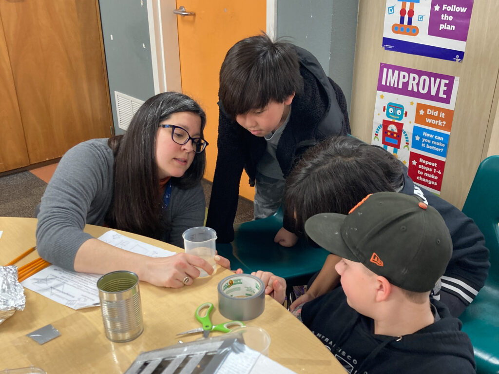 teacher leading students in a classroom science experiment